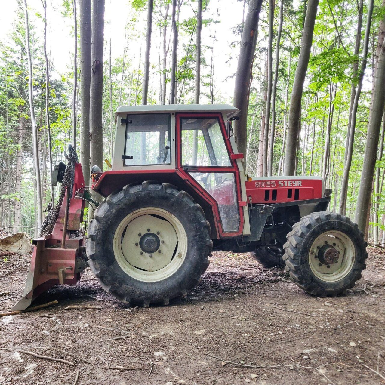 Steyr 8055 mit Kabine und Seilwinde im Wald